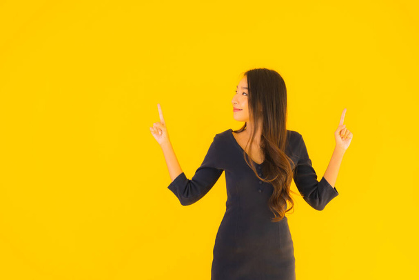 Portrait beautiful young asian woman with action on isolated yellow background - Foto, Imagen