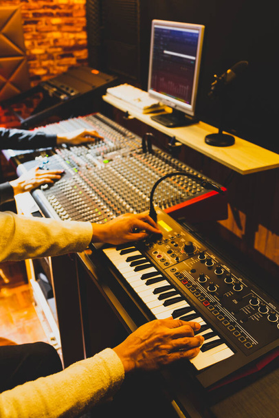 professional musician working with sound engineer in recording studio - Фото, зображення