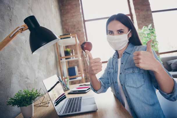 Profile side photo of positive girl manager have corona virus infection self quarantine work home approve internet connection show thumb up sign sit desk wear respiratory mask in house indoors - Valokuva, kuva