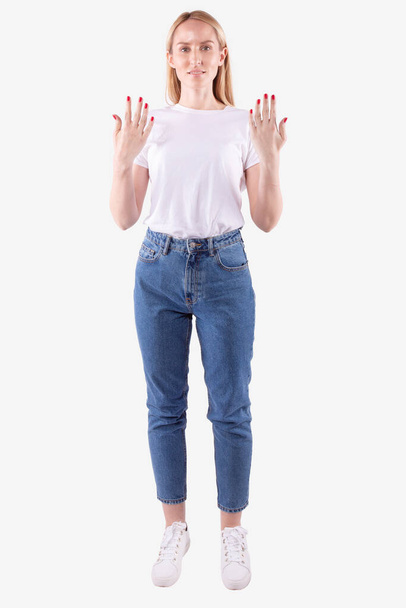 Young caucasian woman shows reverse side of palms. White background. Full length - Фото, зображення