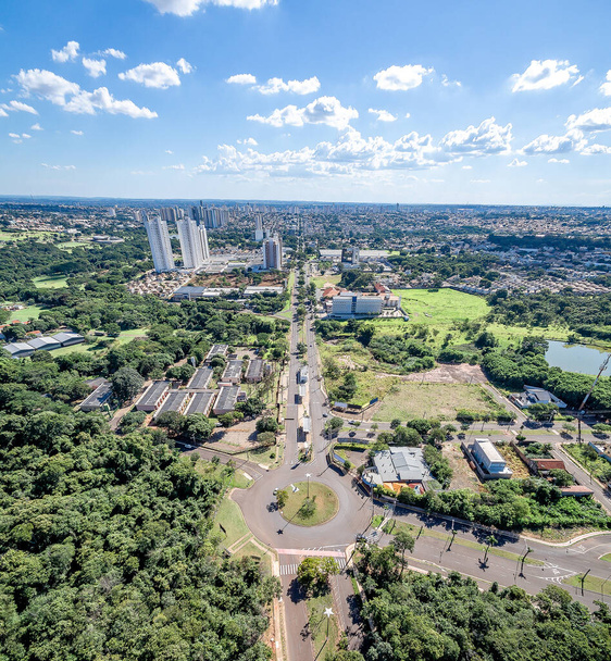 Luchtfoto van de rotonde aan het einde van de Avenida Mato Grosso aan de Campo Grande MS, Brazilië. Zicht op de lange tweerichtingsweg. beboste stad met veel groene bomen rond de stad. - Foto, afbeelding