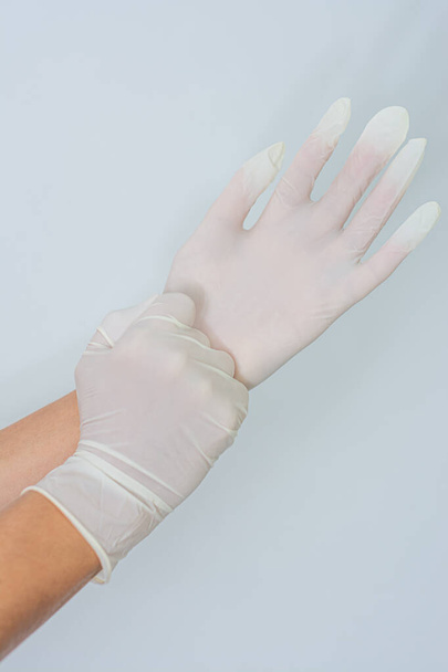 Frauenhände ziehen Latexhandschuhe an - Foto, Bild