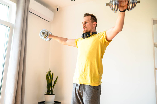 A young guy in sport wear is training at home - Foto, Bild