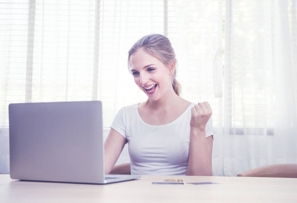 Beautiful happy caucasian woman in casual communicate via computer by video chat in living room.Work at home,stay at home and social distancing concept. - Photo, Image