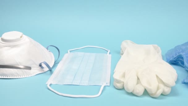 Medical personal protective equipment on a blue background. - Video