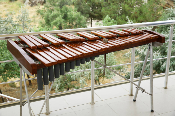 音楽教室で木製の木琴。Xylophone 、 wenote 。Xylophoneクローズアップ、木製打楽器緑の背景。タイの木製のアルト木琴楽器. - 写真・画像