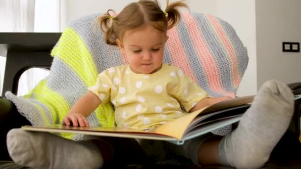 Cute toddler reading book at home - Footage, Video