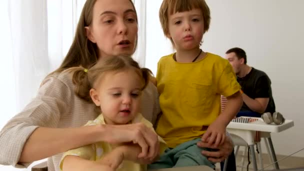 Exhausted businesswoman taking care of kids at home - Video