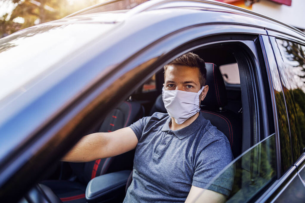 Man with protective mask and gloves driving a car. Infection prevention and control of epidemic. World pandemic. Stay safe. - Φωτογραφία, εικόνα