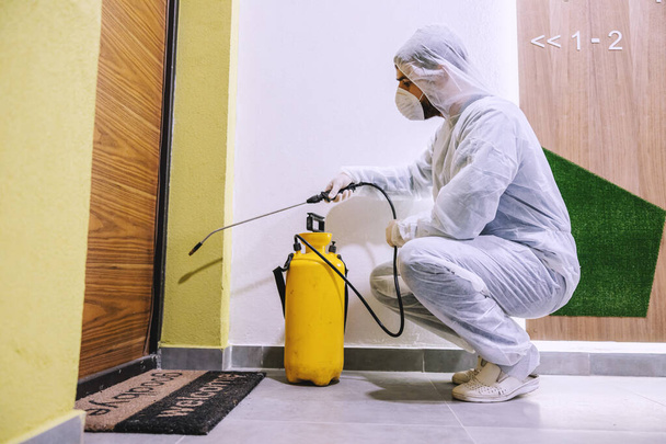 Sanitizing interior surfaces. Cleaning and Disinfection inside buildings, the coronavirus epidemic. Professional teams for disinfection efforts. Infection prevention and control of epidemic. Protective suit and mask. - Photo, Image