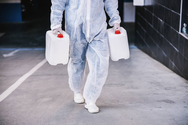 Szakosodott vegyvédelmi ruhák felkészítése tisztítására és fertőtlenítésére koronavírus sejtek járvány, világjárvány egészségügyi kockázat.  - Fotó, kép