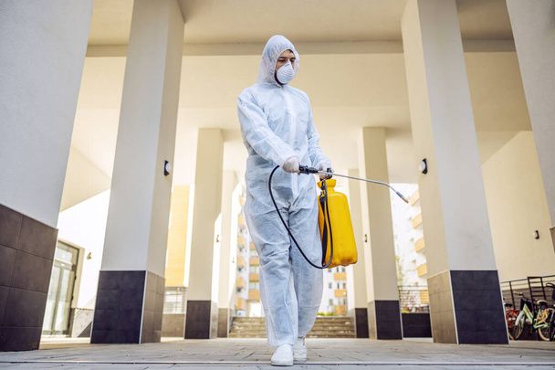 Cleaning and Disinfection outside around buildings, the coronavirus epidemic. Professional teams for disinfection efforts. Infection prevention and control of epidemic. Protective suit and mask. - Photo, Image