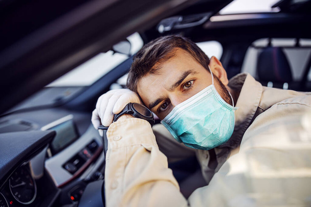 Hombre con máscara protectora y guantes conduciendo un coche. Prevención de infecciones y control de epidemias. pandemia mundial. Mantente a salvo. - Foto, imagen