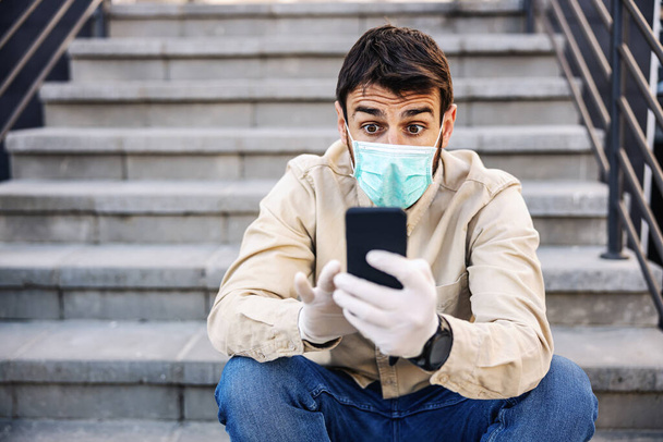 Uomo in tuta protettiva con maschera di digitazione su smartphone cellulare, prevenire l'infezione del virus Covid-19 coronavirus, contaminazione di germi o batteri. Prevenzione delle infezioni e controllo delle epidemie. Tuta protettiva e maschera
. - Foto, immagini