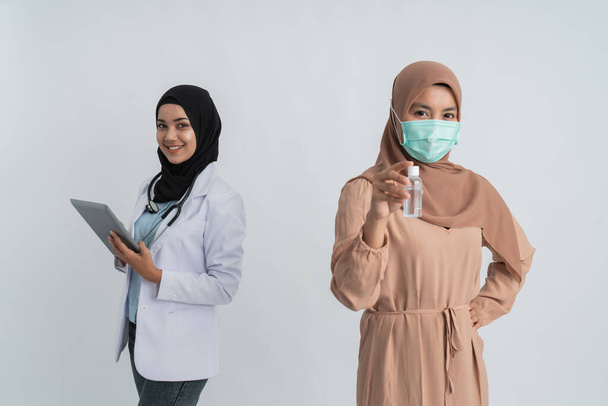 muslim woman with masks holding hand sanitizer - Zdjęcie, obraz