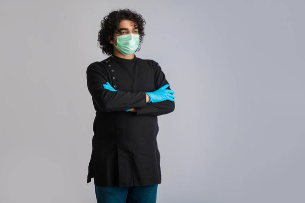 Closeup portrait of a young man wearing a medical or surgical mask - Photo, image