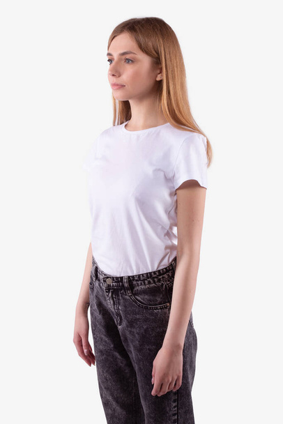 Caucasian teen girl casually dressed stands half-sides and looks straight ahead - Photo, image