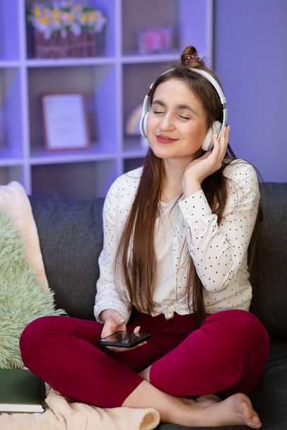 Woman listening music in headphones in room. - Fotoğraf, Görsel