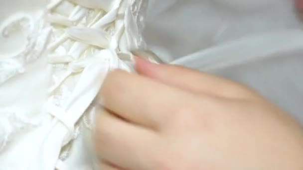 νύφη σφίγγει τον κορσέ της στο νυφικό της - Πλάνα, βίντεο