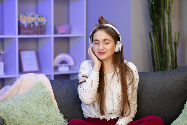 Attractive schoolgirl listening music through headphones, eyes closed - Fotoğraf, Görsel