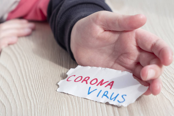 Child hand hold peper with CORONAVIRUS. Quarantine - Fotoğraf, Görsel