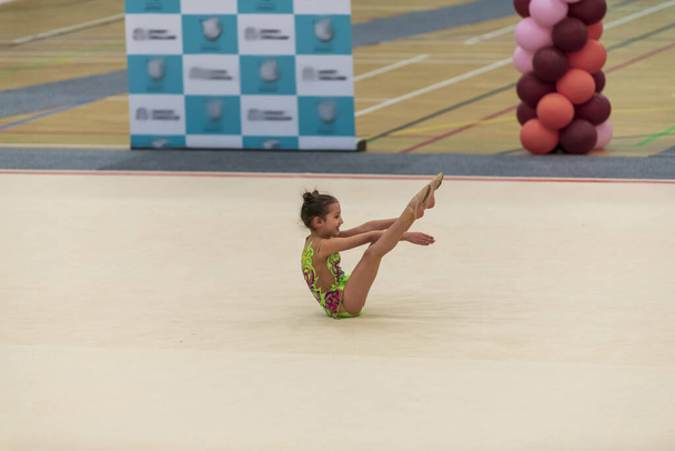 Portrait of a young gymnast. Portrait of a 7 years old girl in rhythmic gymnastics competitions - Photo, Image