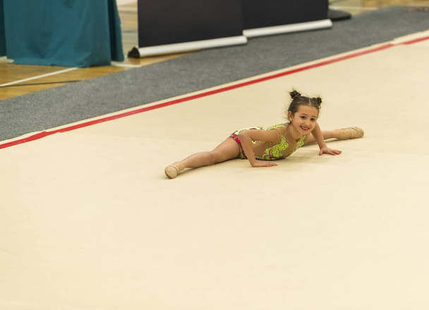 Retrato de una joven gimnasta. Retrato de una niña de 7 años en competiciones de gimnasia rítmica
 - Foto, Imagen