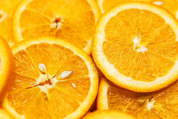 .Bright orange background with slices of juicy oranges. Orange in the section. Orange-abstract fruit background, natural vitamins. Backgrounds and textures. - Photo, image