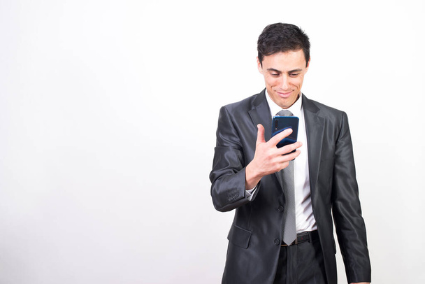 muž v obleku rád mluví na mobilu. Bílé pozadí, Střední snímek - Fotografie, Obrázek
