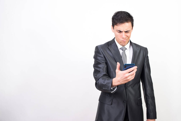 Un uomo in giacca e cravatta preoccupato sul cellulare. Fondo bianco, scatto medio
 - Foto, immagini