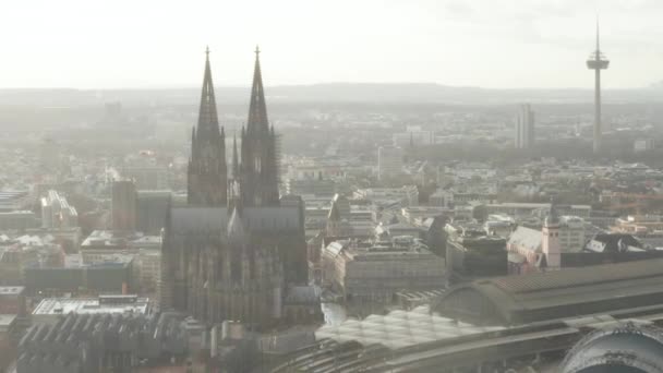AERIAL: Κολωνία Hohenzollern Bridge και Θέα στον καθεδρικό ναό με κεντρικό σιδηροδρομικό σταθμό στο όμορφο θολό φως του ήλιου  - Πλάνα, βίντεο