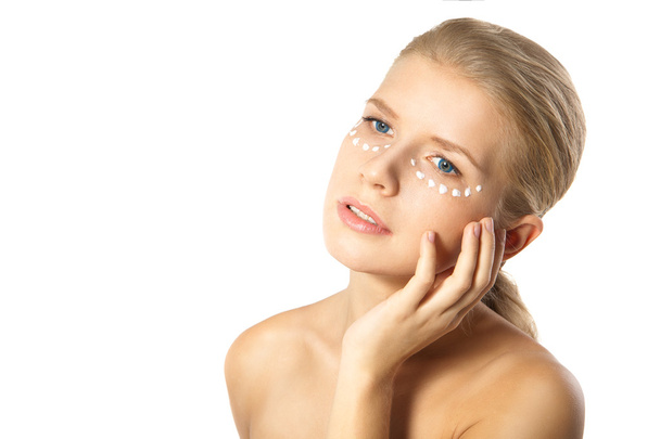 Woman applying moisturizer cream on face isolated - Foto, afbeelding