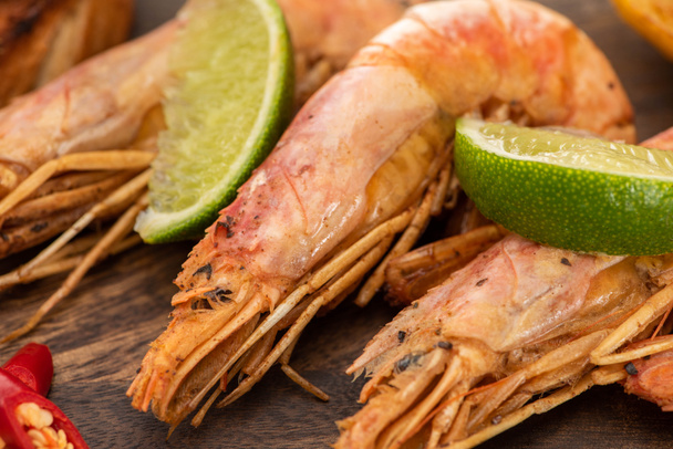 close up view of fried shrimps with chili and lime on wooden board - Φωτογραφία, εικόνα