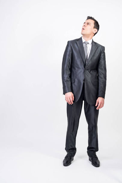 Doubting man in suit. White background, full body - Photo, image