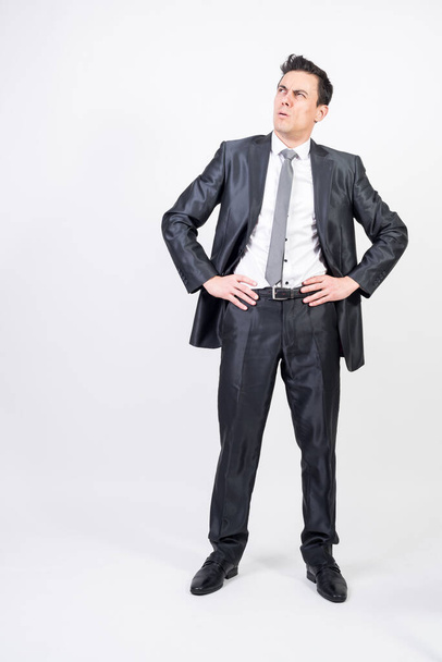 Doubting man in suit. White background, full body - Φωτογραφία, εικόνα