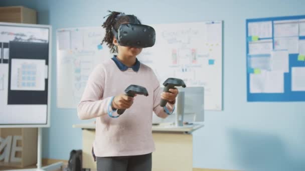 Elementary School Computer Science Class: Cute Girl Wearing Augmented Reality Headset and Using Controllers Learns Lessons in Virtual Reality Excited, Curious and Interested in Knowledge - Séquence, vidéo