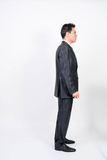 Man in suit in profile. White background, full body. - Zdjęcie, obraz