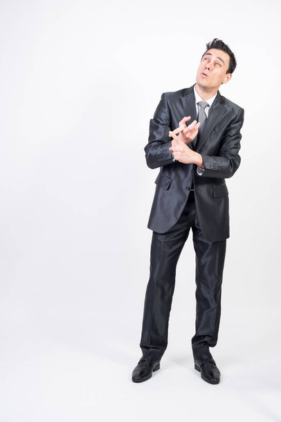 Man in suit counting on fingers. White background, full body - Foto, Imagen