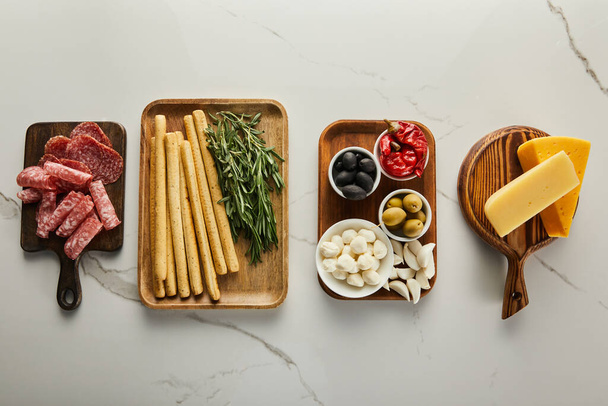 Flat lay with antipasto ingredients on boards on white background - Fotografie, Obrázek