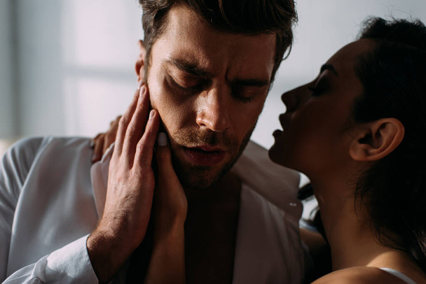 Nainen halaus ja suudella liikemies suljetut silmät makuuhuoneessa
 - Valokuva, kuva