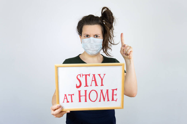 Woman holding sign Stay Home Save Lives global message coronavirus. Quarantine to fight COVID-19 pandemic. - Fotó, kép