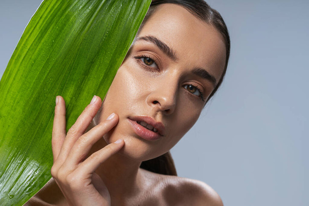 Young attractive natural girl with green leaf - Fotó, kép