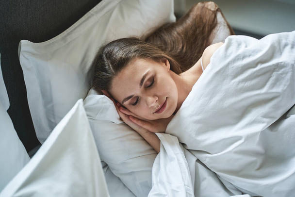 Good-looking young female lying in a bedroom - Фото, зображення
