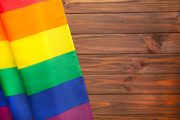 Rainbow LGBT flag on brown wooden background, top view - Foto, Bild