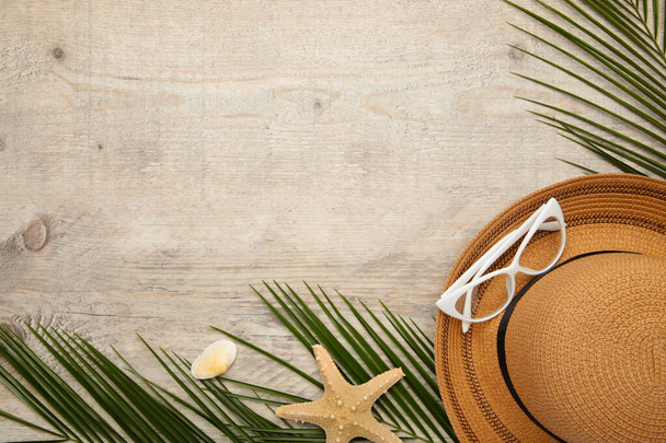 Beach accessories with palm leaves on light background with copy space - Photo, Image