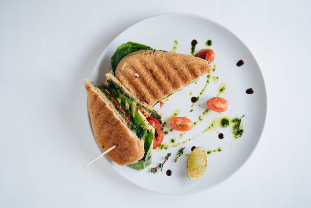 Panini with cheese paprika and pesto on the white plate on the white plate - 写真・画像