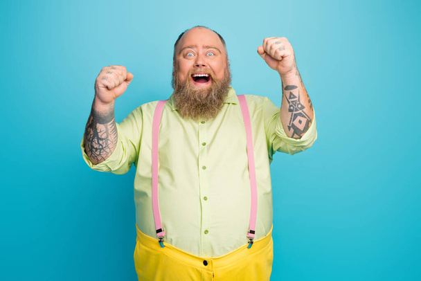 Portrait of his he nice attractive cheerful cheery glad bearded mature guy celebrating victory occasion isolated over bright vivid shine vibrant blue color background - 写真・画像