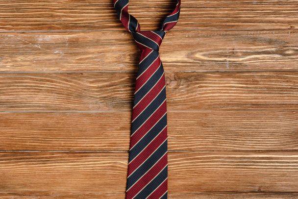 Top view of mens striped fabric tie on wooden background - Foto, imagen