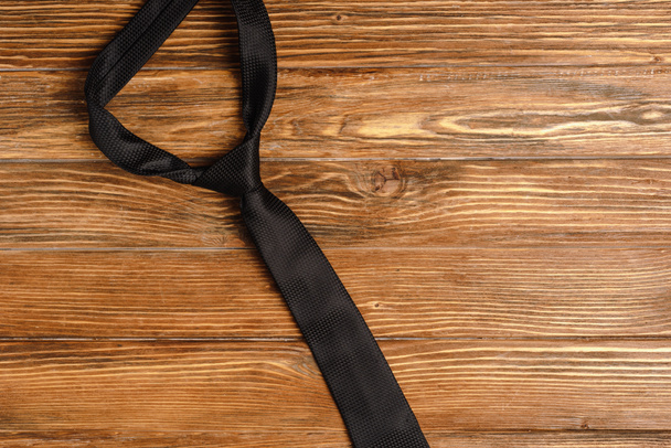 top view of mens plain black tie on wooden background - Фото, зображення