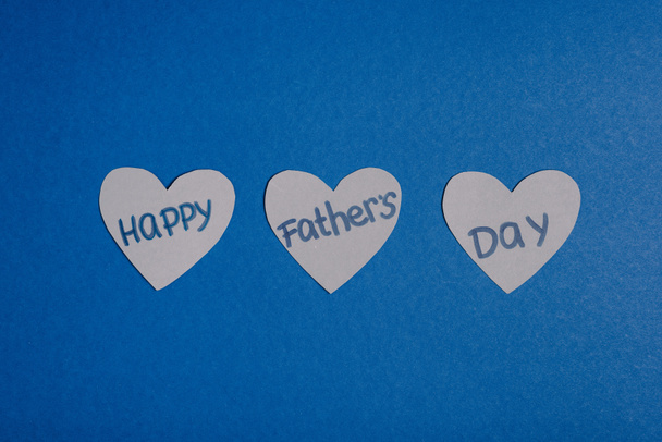 top view of grey paper crafted hearts with lettering happy fathers day on blue background - Photo, Image